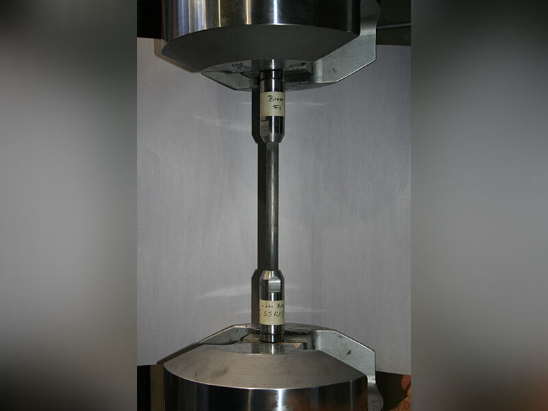 Megalex™ sucker rod extended and attached to a metallic fixture with a grey wall in the background.